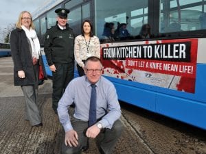 Alderman Robert Smith, Chair of the Policing and Community Safety Partnership with Alison Clenaghan, PCSP manager, Sergeant Billy Wilson, PSNI and Aisling Gillespie. PCSP project co-ordinator with the new 'Knife Crime' campaign posters on buses.