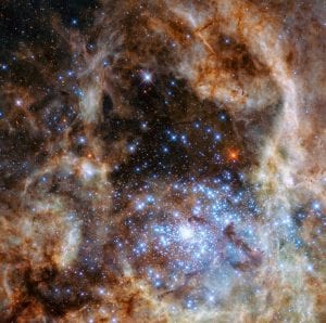 The image shows the central region of the Tarantula Nebula in the Large Magellanic Cloud. The young and dense star cluster R136 can be seen at the lower right of the image. This cluster contains hundreds of young blue stars, among them the most massive star detected in the Universe so far. Using the NASA/ESA Hubble Space Telescope astronomers were able to study the central and most dense region of this cluster in detail. Here they found nine stars with more than 100 solar masses.