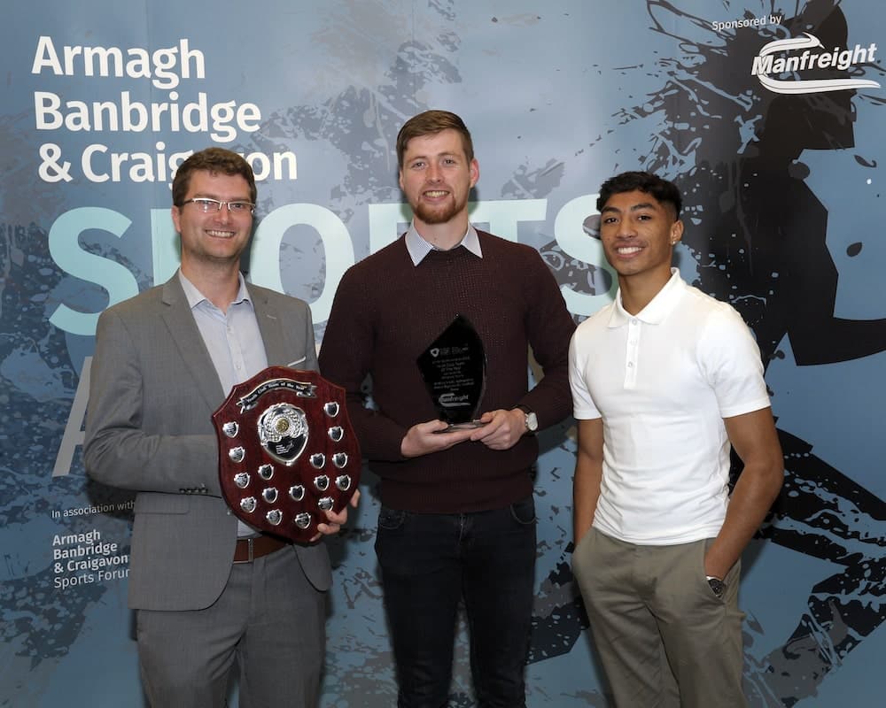 Councillor Peter Lavery accepts the award for Youth Club Team, sponsored by McKeeer Sports, on behalf of St Mary’s GAC, Aghagallon Minor Gaelic Football Team. Conor Martin from McKeever Sports and Commonwealth Games athlete Clepson Dos Santos present the award.