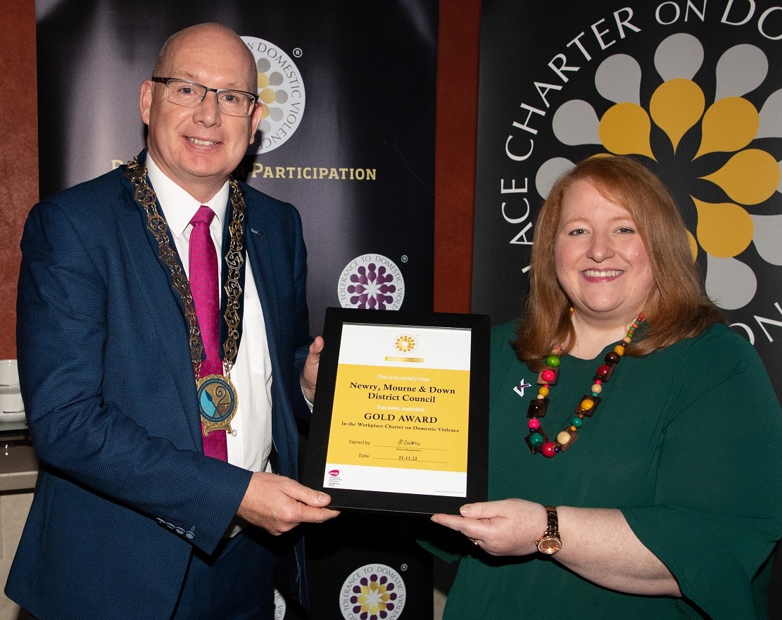MLA Naomi Long presents the Gold Certificate to council chairperson Michael Savage at the Onus NI awards ceremony in November   