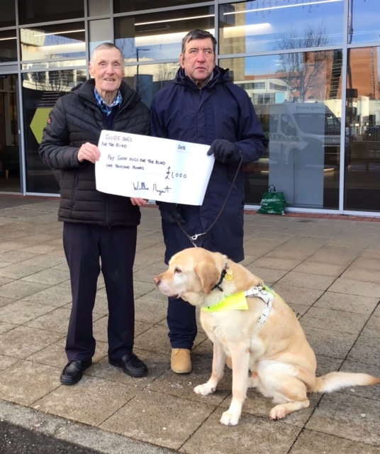 Paul Hunt with his guide dog Yeoman accepting cheque on behalf of Guide Dogs for the Blind
