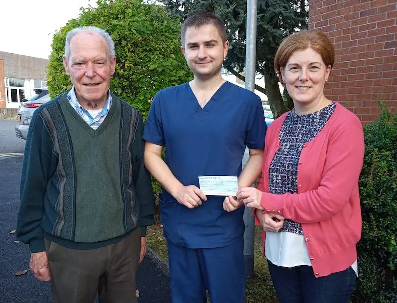 Vincent Lennon and daughter Fiona McKenna presenting a cheque to Dr Sherry of the Acute Care at Home Service.