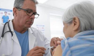 A doctor administering a flu vaccination to an elderly patient